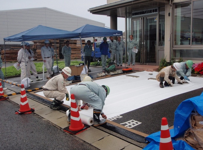 アスファルトの上にシート敷設